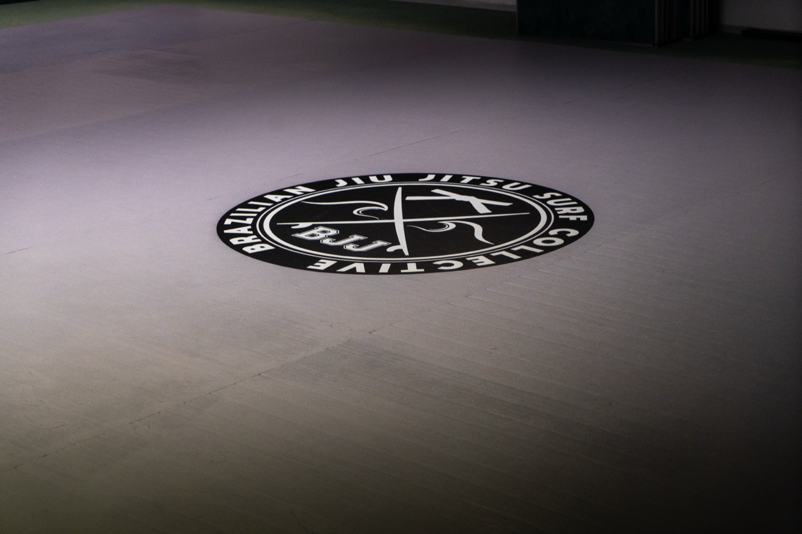 Le tatami du BJJ Surf Collective et son logo